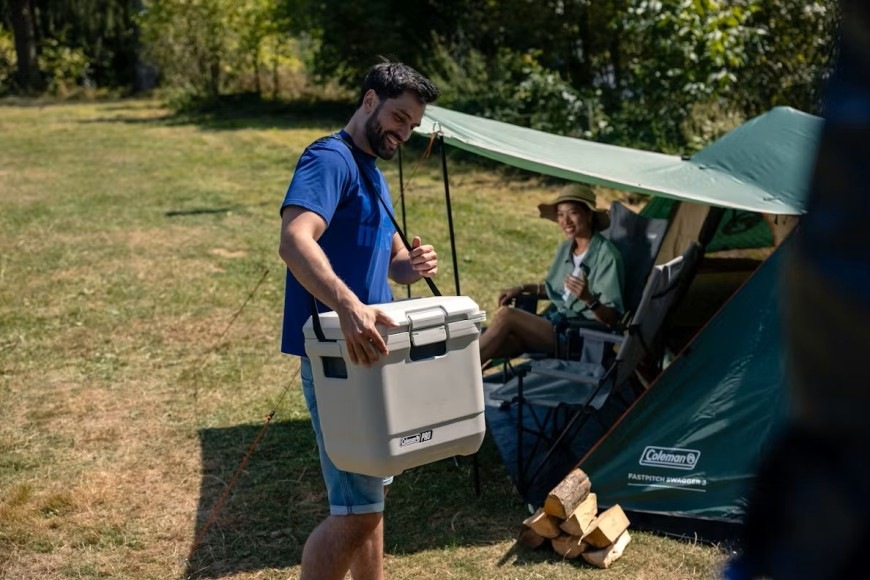 Muž nesoucí chladicí box COLEMAN PRO 25QT o objemu 24 l