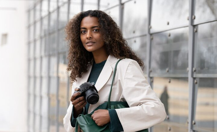 Objektiv Sony E 11 mm f/1.8 černý Model vyndává fotoaparát z brašny