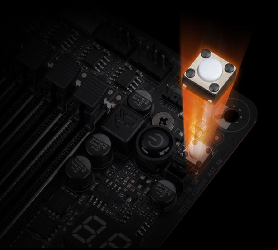 Základní deska GIGABYTE TRX50 AERO D Detail základní desky počítače s oranžovým světlem osvětlujícím kulaté tlačítko. Tmavé pozadí zvýrazňuje detaily složitých obvodů.