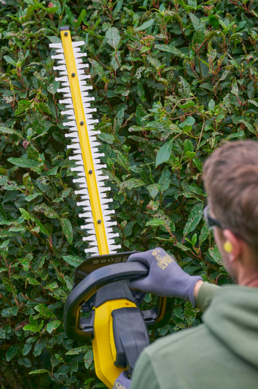 Nůžky na živý plot Stanley FatMax SFMCHT655M1-QW (s baterií) Detail lišty 55 cm nůžek Stanley FatMax SFMCHT655M1-QW při stříhání živého plotu