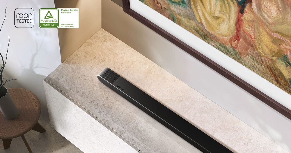 Soundbar Samsung HW-S800D leží na televizním stolku pod TV Samsung Frame
