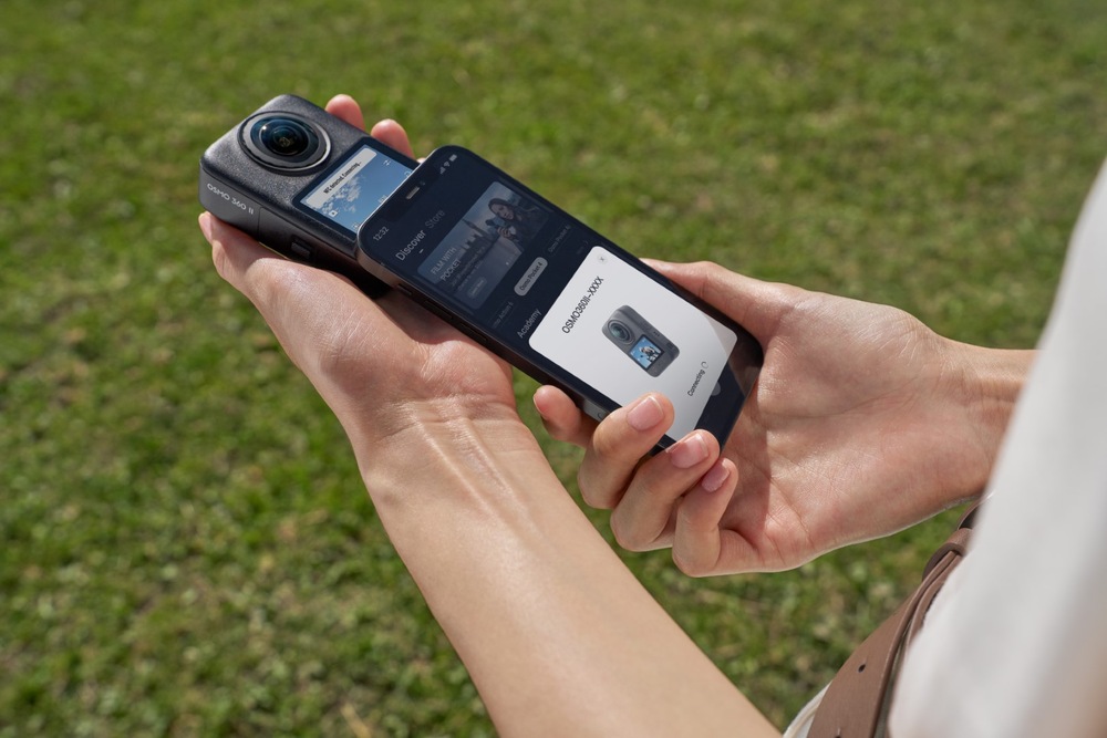 Outdoorová kamera DJI Osmo 360 II Adventure Combo černá Ruce drží kameru DJI Osmo 360 II vedle chytrého telefonu při připojování k mobilní aplikaci
