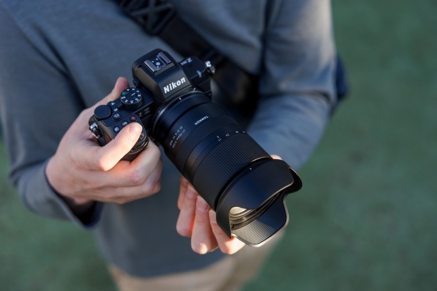 Objektiv Tamron 17-70 mm f/2.8 Di III-a RXD (Nikon) černý Muž držící fotoaparát Nikon s objektivem Tamron 17–70 mm f/2.8 Di III-a RXD