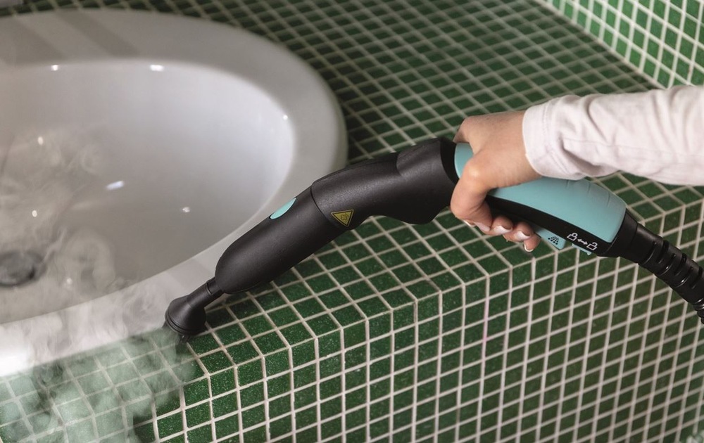 Parní čistič Ariete XVapor ART 4145/BL tmavě modrý čištění parním čističem Ariete ART 4145/BL XVapor okolí umyvadla posazeného v prostoru se zelenou keramickou mozaikou