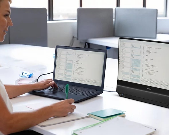 Žena pracuje na notebooku s připojeným displejem Philips 24B2D5300/00