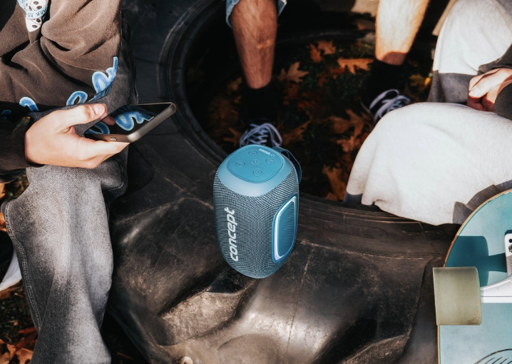 Modrý reproduktor Concept SoundJoy BR5022 přehrává hudbu skupině mladých lidí se skateboardy