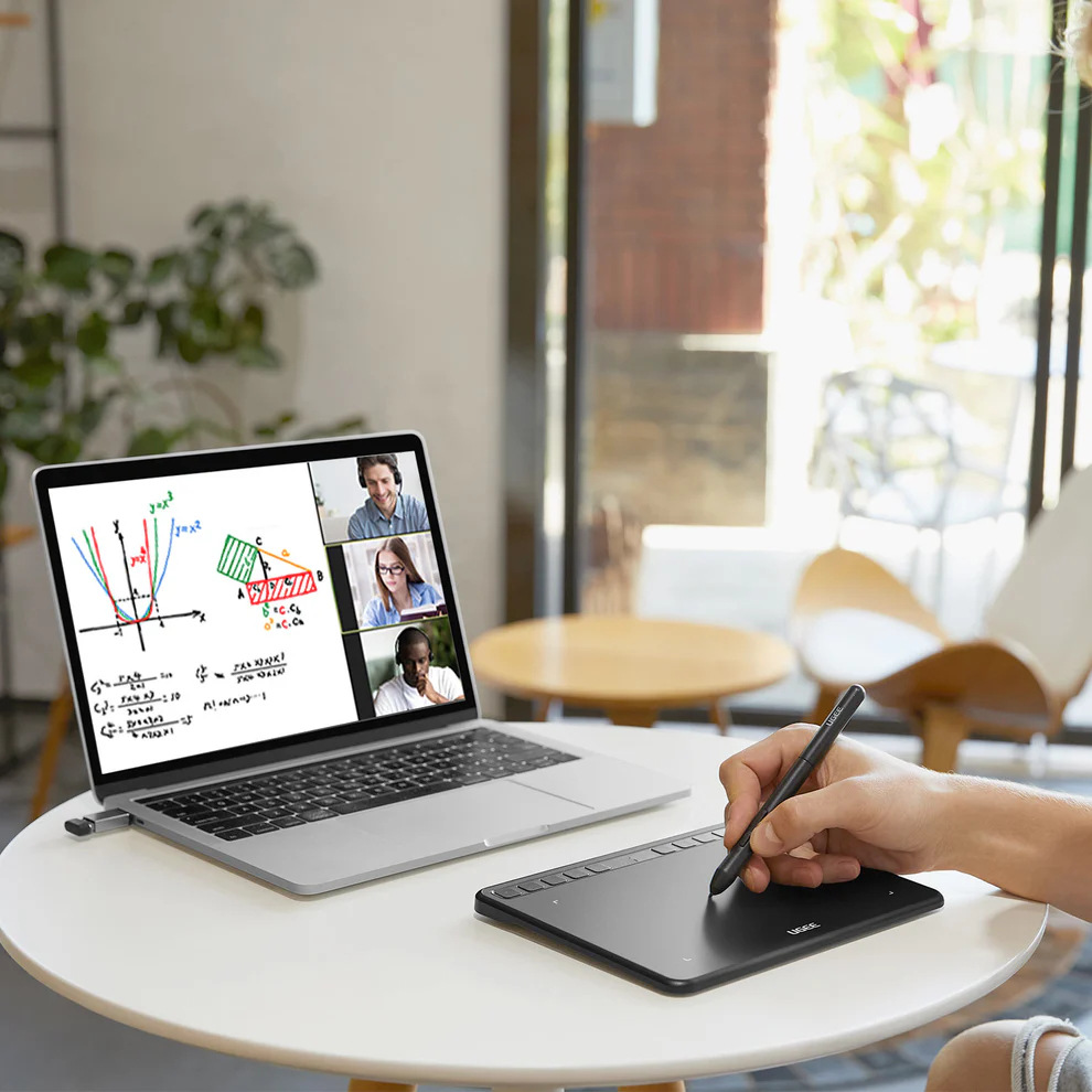 Ruka kreslící grafy a výpočty na tabletu UGEE S640 během on-line výuky matematiky