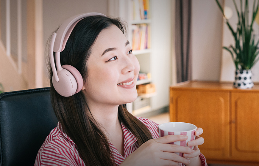 Headset Logitech Zone Wireless 2 ES růžový Žena relaxující s headsetem Logitech Zone Wireless 2 ES při poslechu hudby doma