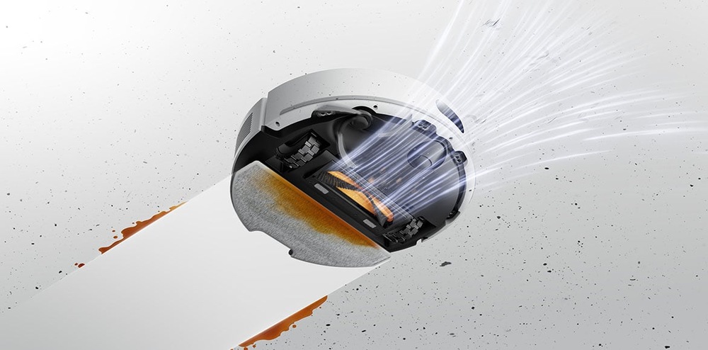 Pohled zespodu na robotický vysavač Dreame F20 Plus, který nasává nečistoty a zároveň za sebou nechává čistou vytřenou podlahu.