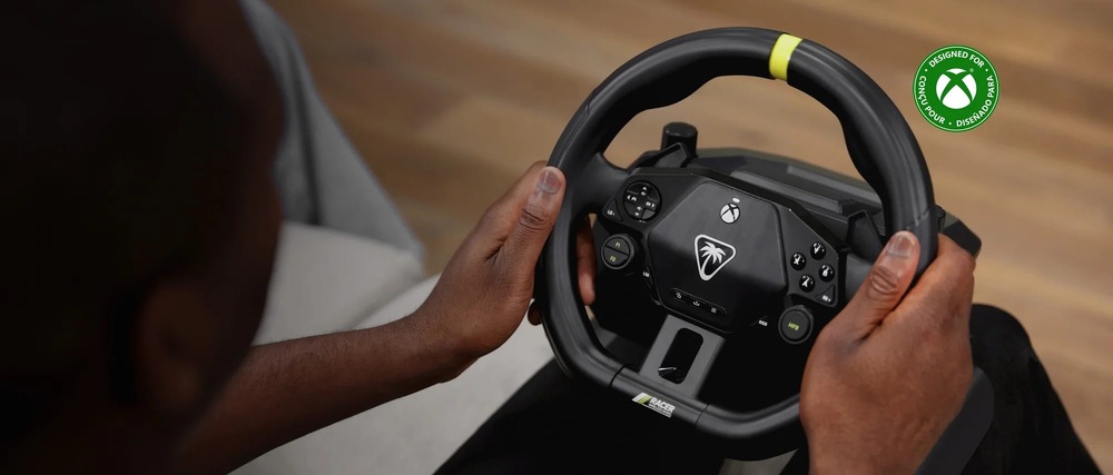 Volant Turtle Beach Racer - PC, Xbox One/Series černý Záběr na osobu držící v rukou věnec volantu Turtle Beach Racer. s dřevěnou podlahou v pozadí.