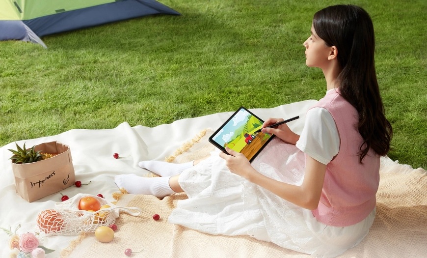 Grafický tablet UGEE UT2 černý Žena sedící na piknikové dece v parku má rozkreslený obrázek na tabletu UGEE UT2