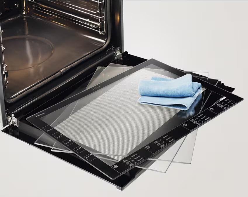 Otevřená dvířka trouby Electrolux. Na nich položené skla a měkký hadřík.