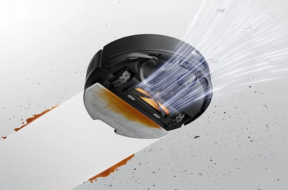 Pohled zespodu na robotický vysavač Dreame F20 Plus, který nasává nečistoty a zároveň za sebou nechává čistou vytřenou podlahu.