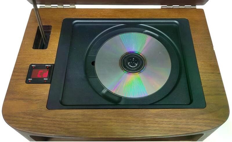 Radiopřijímač s CD Roadstar HRA-1500UEMP hnědý Pohled zepředu na rádio Roadstar HRA-1500UEMP s vyklopeným horním víkem a žlutou stupnicí tuneru.