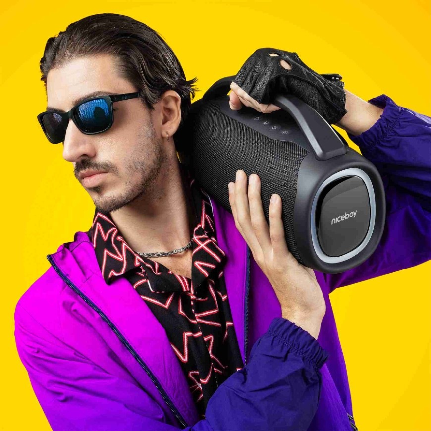 Přenosný reproduktor Niceboy Vulcan černý Muž nesoucí na rameni reproduktor Niceboy Vulcan s praktickým madlem