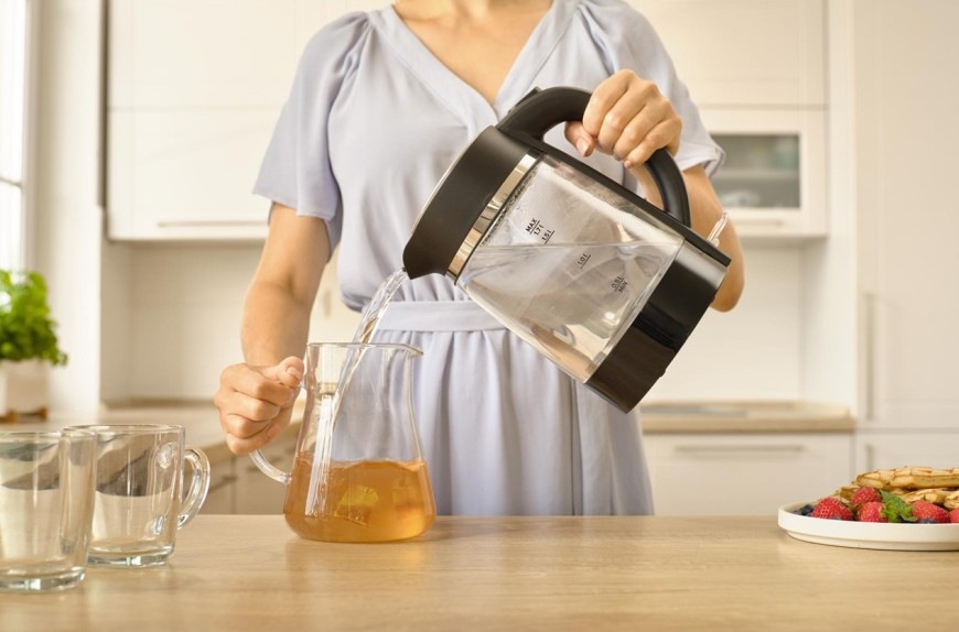 Žena zalévající čaj horkou vodou z konvice Sencor SWK 2711BK o objemu 1,7 l