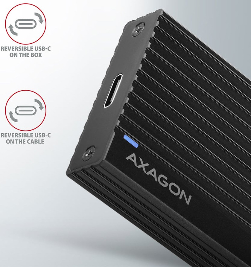 Na obrázku je detail černého externího boxu AXAGON pro M.2 SSD. Je vidět rohová část zařízení s USB-C konektorem, malou modrou kontrolkou a výrazným podélným žebrováním po povrchu. Vedle jsou dvě jednoduché ikony s textem, které upozorňují na oboustranný USB-C konektor na boxu i na kabelu.