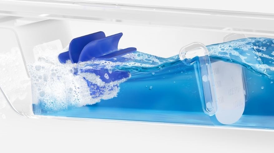 detail na promíchaní pracího gelu s vodou za ucelem vyroby bublinek, které lepe proniknou do vlaken prádla,