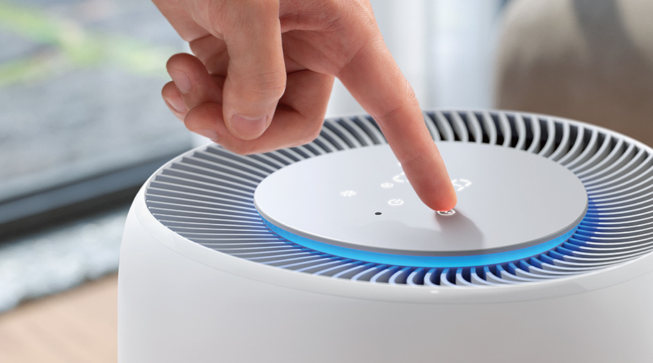 Ženská ruka ovládající čističku Philips AC2220/10 2000 Series pomocí dotykového displeje