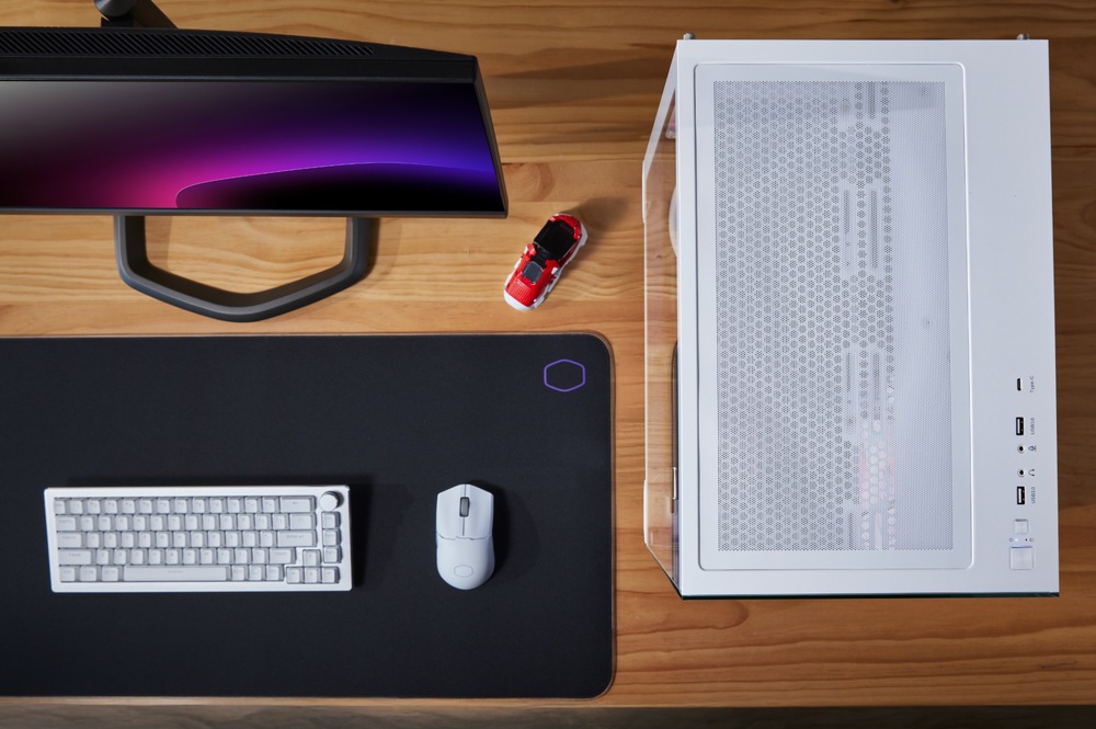 Case Cooler Master WakeUp Elite 681 bílá Pohled shora. Je zde vidět počítač na pracovní desce stolu, klávesnice, myš a porty pro připojení externích zařízení na horní straně skříně.