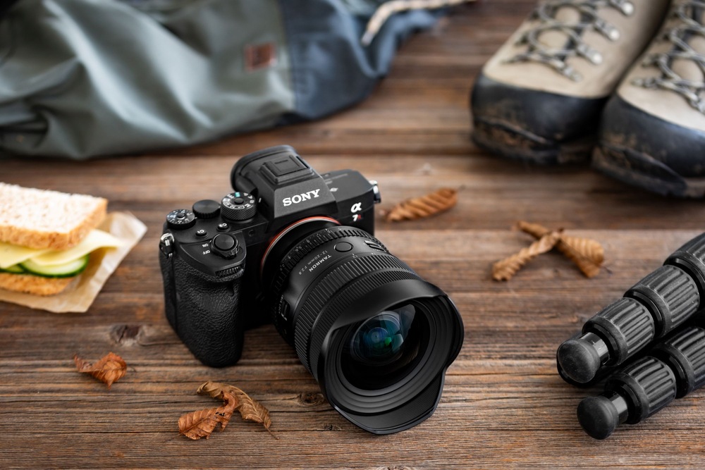Fotoaparát Sony s nasazeným objektivem Tamron 12–20 mm F/2.8 položený na dřevěném stole