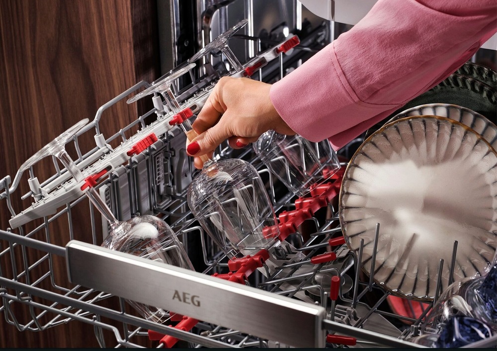 Vysunutý horní šuplík myčky AEG řady 8000 CleaningPerformance. V šuplíku jsou gumové protiskluzné trny a držáky, které drží sklenice se stopkou na svém místě.