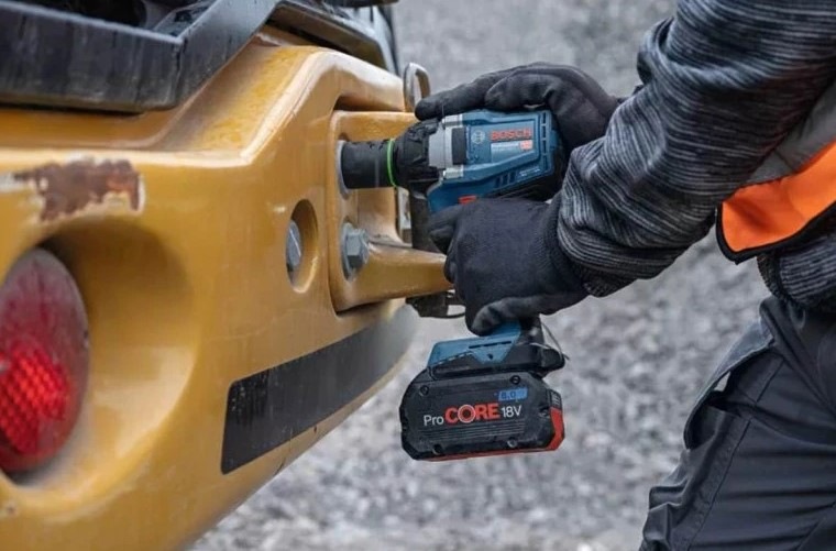 Utahovák rázový Bosch Professional GDS 18V-350 (s baterií) Muž využívá nářadí pro uvolnění nebo utažení matic.