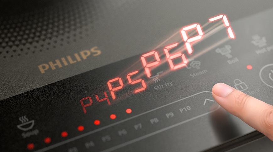 Detail dotykového ovládání indukčního vařiče Philips HD5850/90 5000 Series s LED displejem a přednastavenými programy pro rychlé a pohodlné nastavení výkonu při vaření.