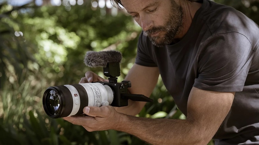 Muž natáčející z ruky s teleobjektivem a fotoaparátem Sony Alpha 6700 s pětiosou stabilizací