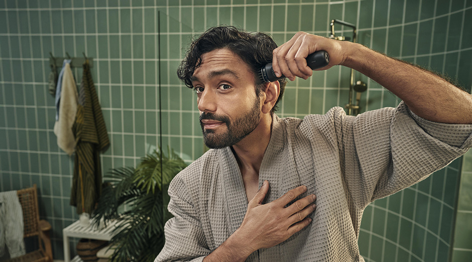 Muž používá hřebenový nástavec k zastřižení vlasů