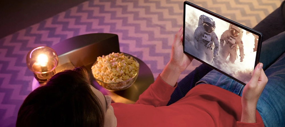 Muž leží a sleduje film na tabletu Lenovo Idea Tab Pro Gen 2