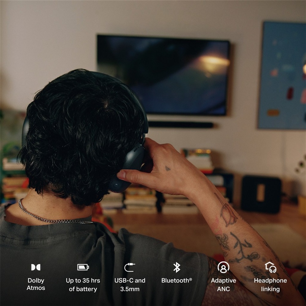 Pohled zezadu na muže držícího náušník sluchátek SONOS Ace Ultra