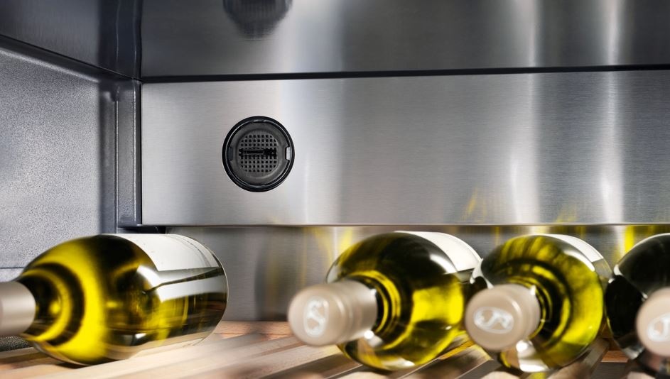 Vinotéka Liebherr Vinothek WKb 1812 černá Lahve uložené ve vinotéce Liebherr WKb 1812, za nimi je vidět filtr s aktivním uhlím FreshAir.