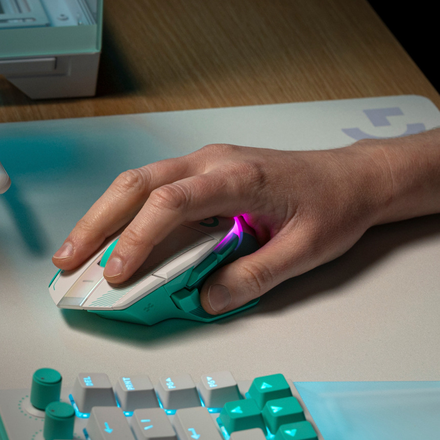 Ruka ovládající myš Logitech G502 X Plus na podložce vedle klávesnice