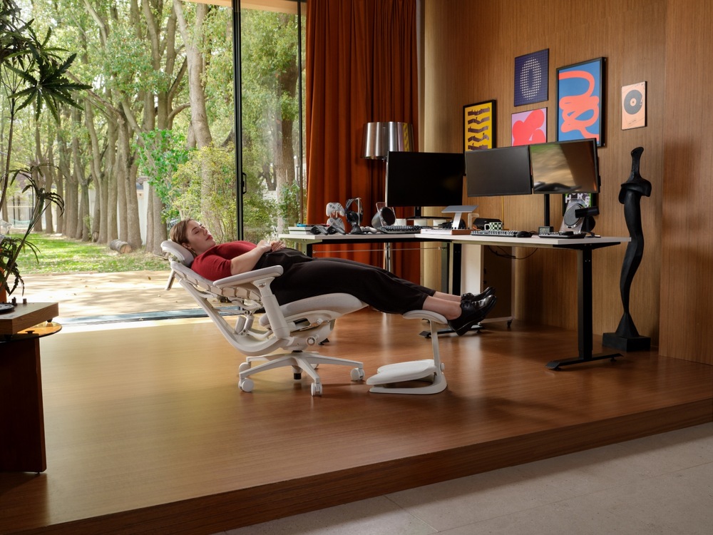 Muž sedící na ergonomické židli LiberNovo Maxis Electric Glacier 52 cm při práci v hudebním studiu