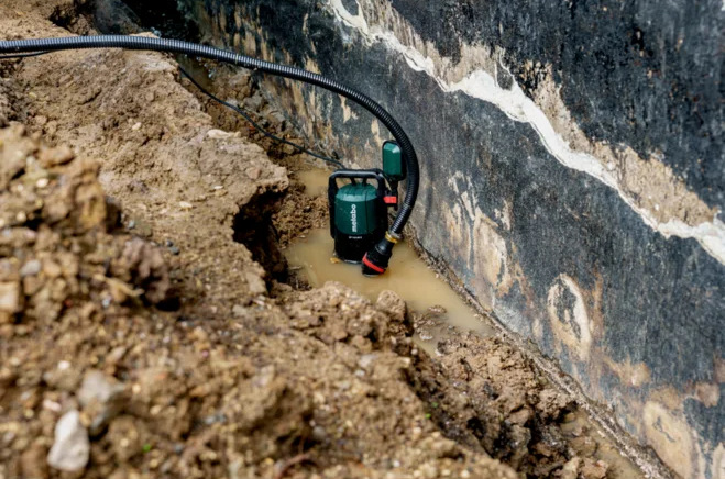 Ponorné čerpadlo Metabo SP 120-35 S při čerpání vody z výkopu u základů budovy.
