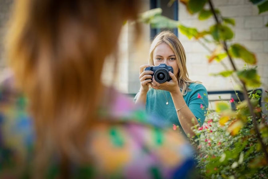 Žena fotografující portrét modelky pomocí fotoaparátu Canon EOS R8