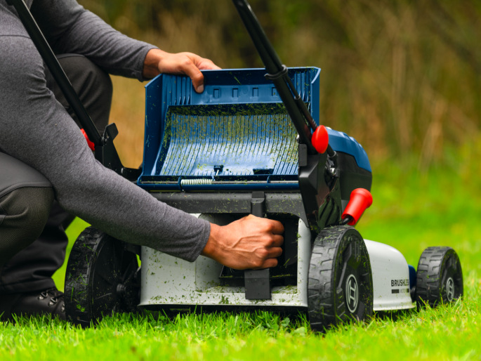 Detail spodní části sekačky Bosch Professional GRA 18V2-46SP při čištění prostoru žacího ústrojí