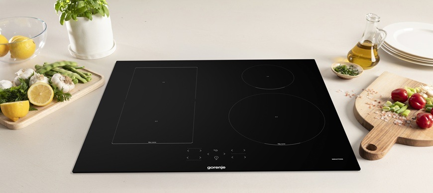 Indukční varná deska Gorenje GI6431BFG v černém provedení je zabudovaná v kuchyňské lince.