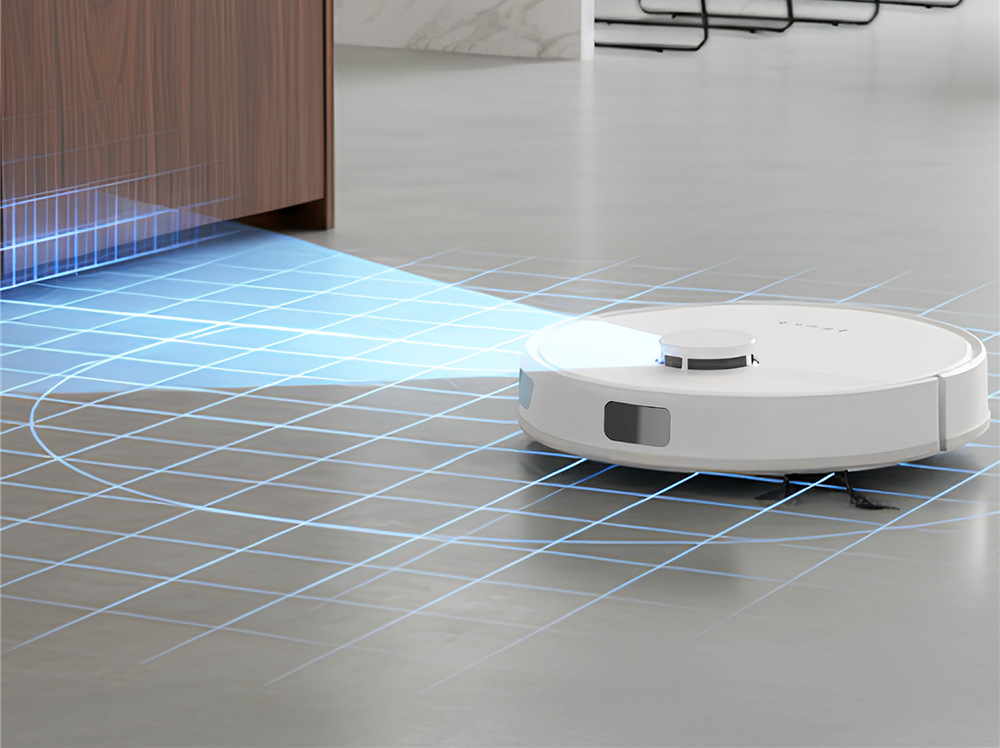 Robotický vysavač Tesla RoboStar iQ660 Plus stojí na zemi u skříňky a mapuje prostor k úklidu, což je znázorněno modrým světlem a modrou mřížkou na podlaze