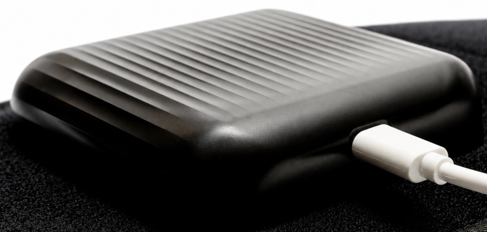 Masážní přístroj Reviber RV-MABP Zen Physio LED černý Detail ovládací jednotky masážního pásu Reviber Zen Physio LED připojené k USB-C kabelu