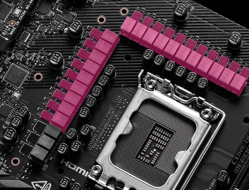 Základní deska MSI MPG Z890 CARBON WIFI Detail počítačové základní desky s paticí pro procesor obklopenou řadami kondenzátorů a růžovými chladiči.