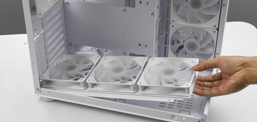 Case Cougar FV150 RGB Dual-Chamber bílá Osoba upravuje držák ventilátorů uvnitř otevřené počítačové skříně. Interiér je čistý a uspořádaný, je vidět několik ventilátorů na svých místech, což naznačuje zaměření na účinnost chlazení.