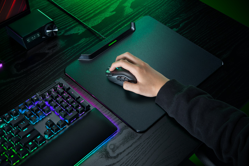 Razer Naga V3 Pro při hraní na herní podložce vedle RGB klávesnice
