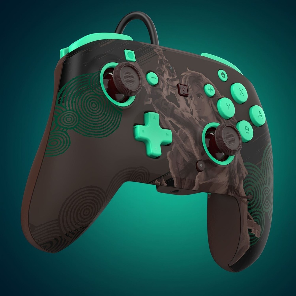 Na obrázku je drátový gamepad Turtle Beach z předního šikmého pohledu s The Legend of Zelda. Přes střed ovladače je jemná ilustrace postav ze světa The Legend of Zelda v tlumených hnědých odstínech. Ovladač má dvě analogové páčky s červenými prvky, červený směrový kříž, tlačítka A, B, X a Y i samostatné tlačítko C. Z horní části vede připojovací kabel.
