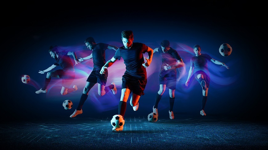 Na obrázku je zachyceno několik dynamických postav fotbalisty v pohybu s míčem, které znázorňují plynulost a ostrost obrazu při sledování sportu. Barevné světelné efekty v modrých a červených odstínech zdůrazňují rychlost a intenzitu akce, symbolizující AI sportovní režim televizoru Hisense 50E7PRO pro detailní a pohlcující sportovní zážitek.
