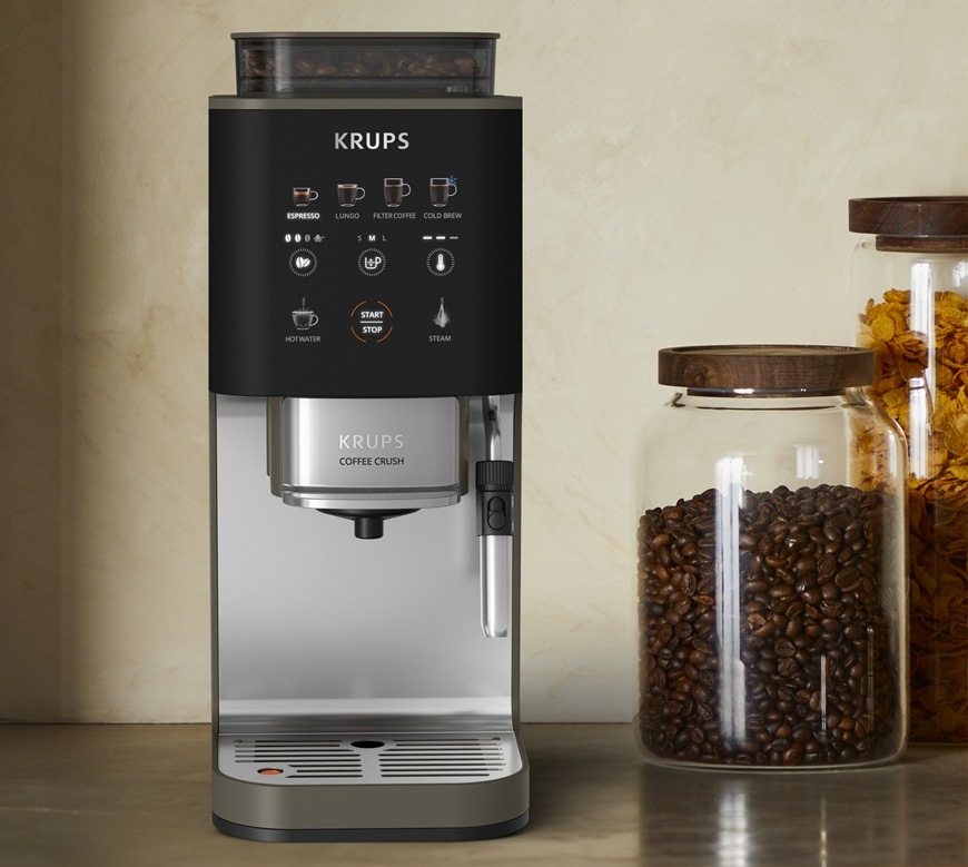Přední pohled na automatický kávovar Krups SA403BE0 Coffee Crush Experience. Vedle něj jsou na stole položené skleněné dózy.