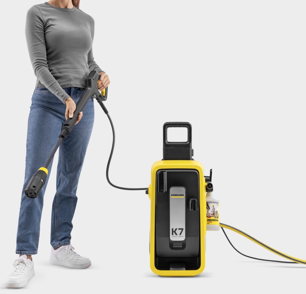 Žena drží vysokotlakou pistoli Kärcher G 180 Q u modelu K 7 Comfort Premium s lahví čisticího prostředku