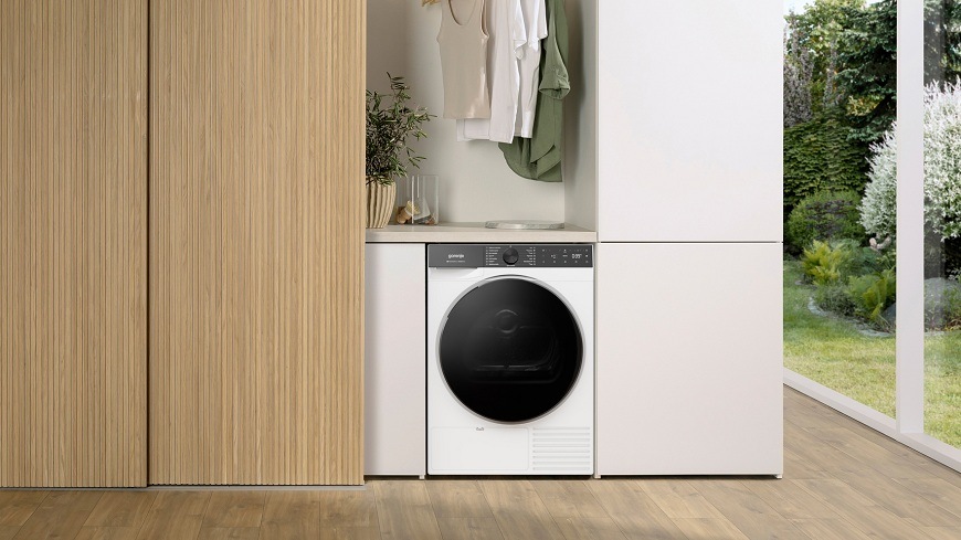 Sušička prádla Gorenje G600 D69B FastDryPro bílá sušička Gorenje D69B v místnosti, visí nad ní prádlo na ramínkách