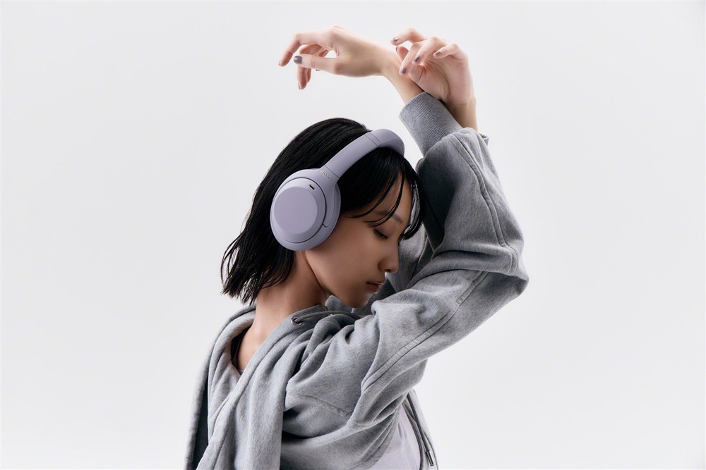 Žena se sluchátky Sony WH-1000XM4C při poslechu hudby a tanci
